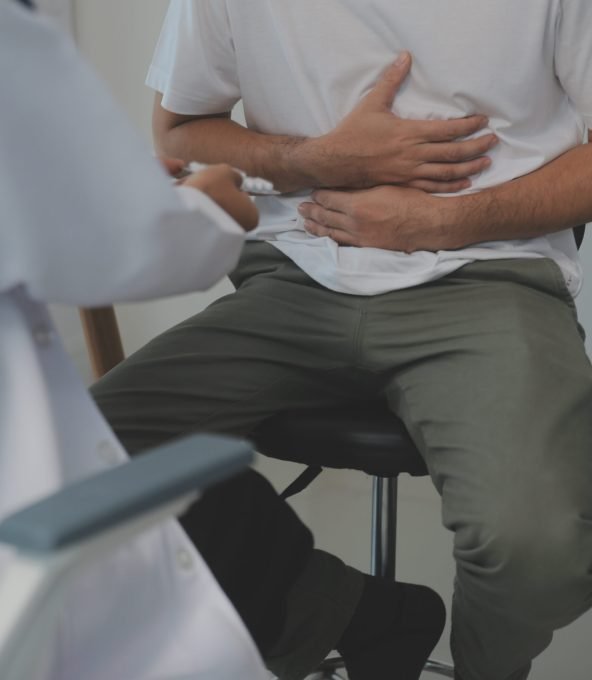 Man suffering with severe stomach pain sitting at home. Hand of mature guy holding abdomen suffering from ache, diarrhea or indigestive problem. Caucasian guy pressing on belly on painful sensation